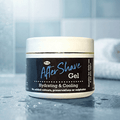Herby After Shave hydrating and cooling balm jar displayed against a clean blue tiled bathroom background.