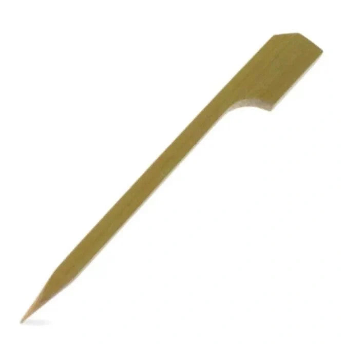 A single small bamboo paddle pick, with a flat paddle-like end and a pointed tip, against a white background.