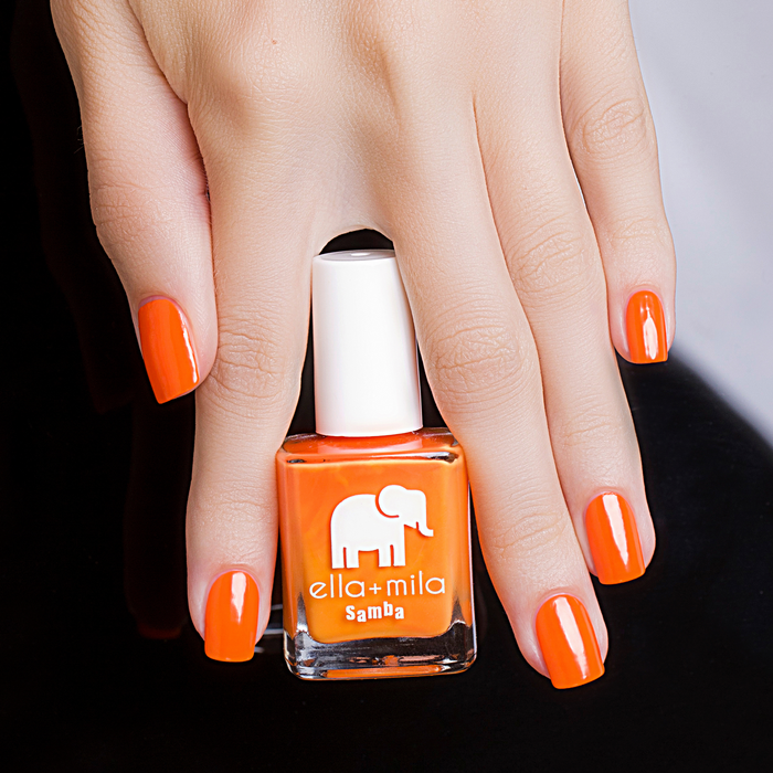 Cause I'm Happy neon orange nail polish manicure holding the bottle