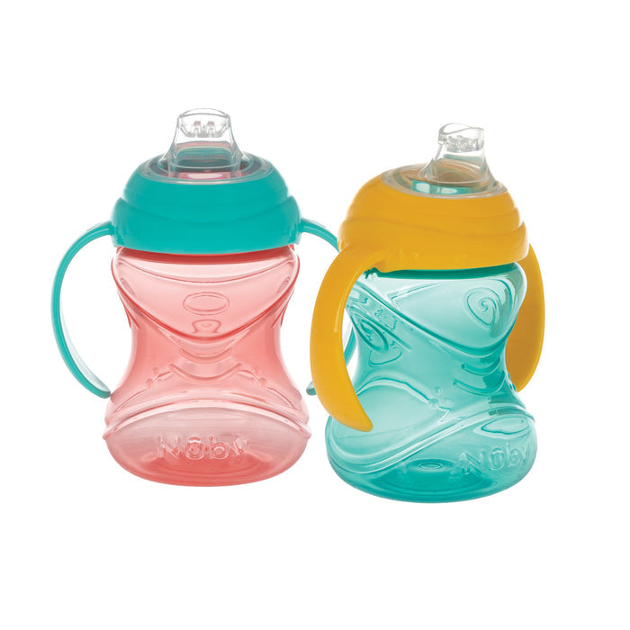 Two Nuby Clik-It Soft Spout Grip N' Sip Trainer Cups (2 Pack) include an aqua cup with yellow lid and a pink cup with teal lid. Both feature clear silicone spouts, embossed Nuby logos, and are designed to be leak proof.