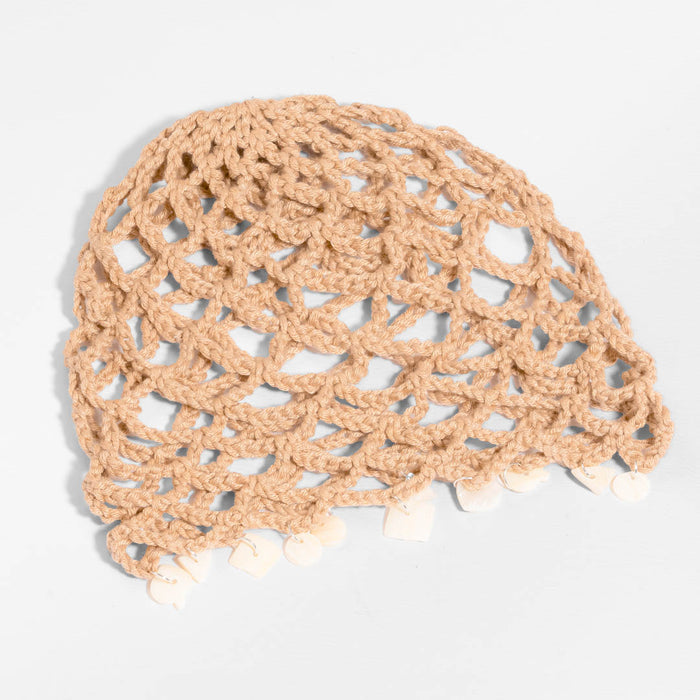 Shell-trimmed crochet beanie hat adding a relaxed boho touch to summer wardrobes.