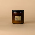 Brown candle with a black lid on a beige background