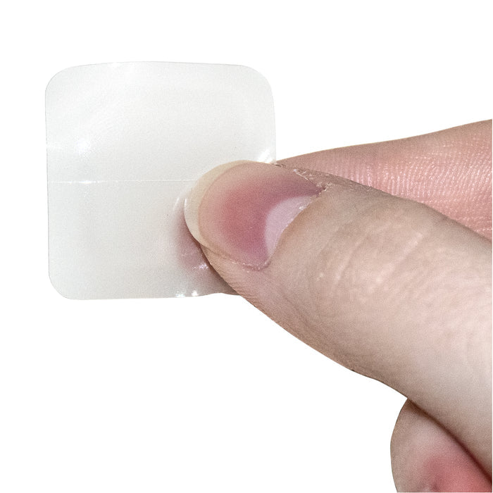 Clear adhesive patch on a finger against a white background