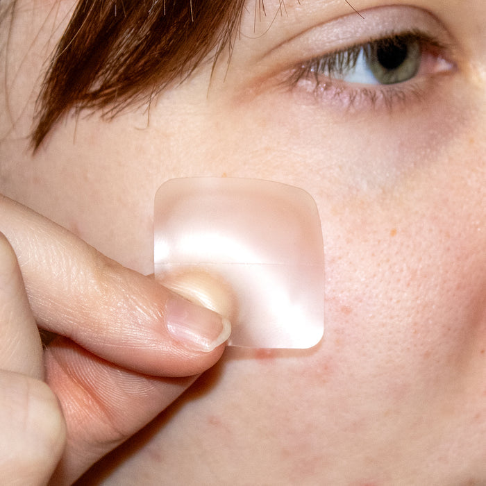 Person applying a clear patch to their skin