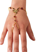 Gold fairy hand chain finger bracelet with red bead accents worn on hand