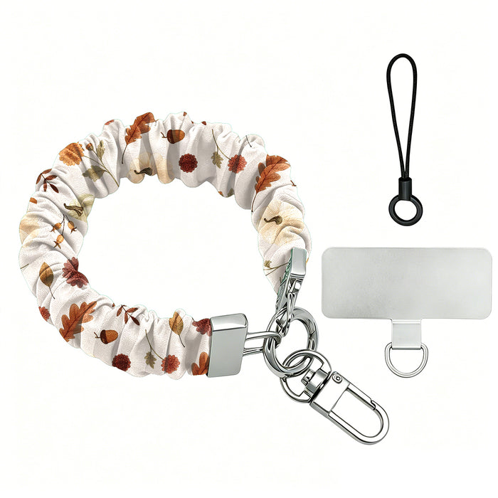 Fall Floral Bliss scrunchie phone wrist strap on a white background, showing the cream fabric with rust and olive autumn florals, silver lobster clasp, black loop cord, and clear attachment tab.