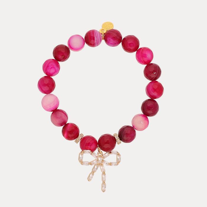 a bracelet with pink beads and a bow