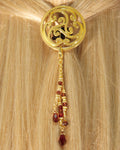 Gold Celtic circle hair hook with dangling red bead charms worn in ponytail, back view