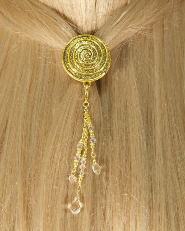 Model wearing a gold spiral hair hook with dangling clear bead charms securing a ponytail.