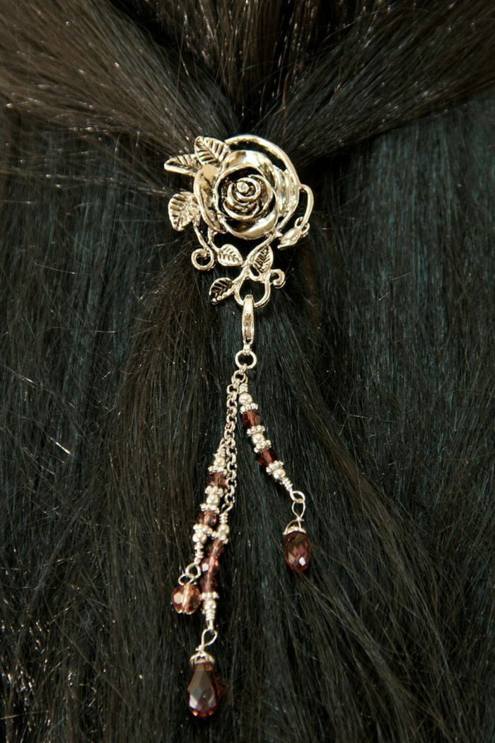 Silver rose hair hook with dangling bead charms worn in dark hair