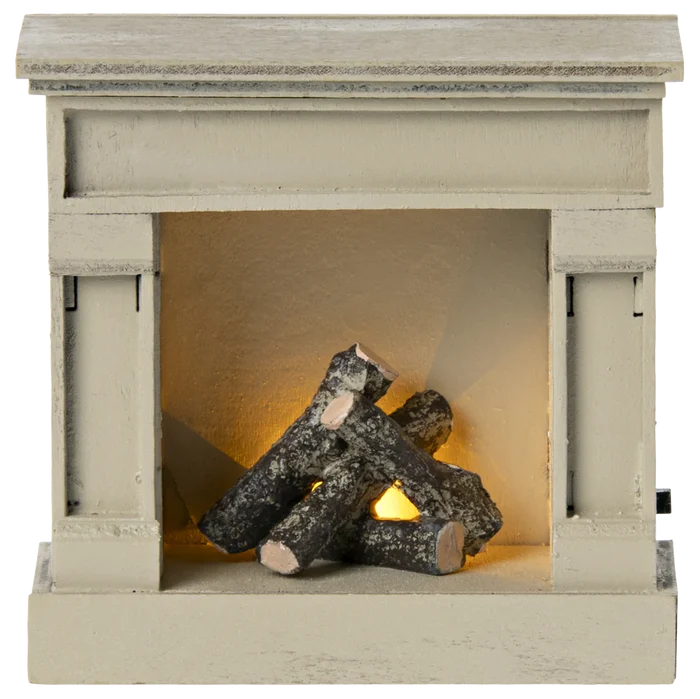 A miniature wooden fireplace with off white color and faux logs inside.