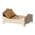 Small bed with a pillow and blanket on a white background