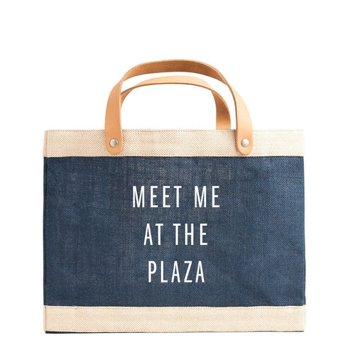 Blue tote bag with 'Meet Me at the Plaza' text on a white background