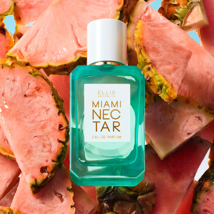 Miami Nectar 50ml Eau De Parfum on slices of pink pineapple, on blue background.
