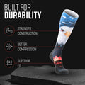 MudGear USA Eagle tall compression sock with blue sky, white clouds, eagle, and red fireworks design on black background