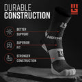 Black and gray MudGear hiking sock displayed on stone, showing compression zones and durable construction details