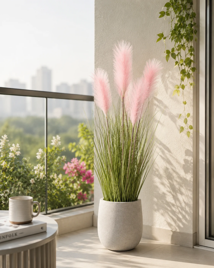 Artificial pampas grass featuring blush pink feather plumes, green stems, and gray pot