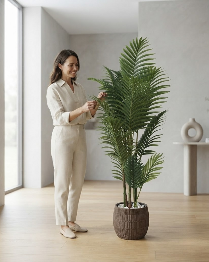 Tall artificial palm with green fronds in dark textured pot