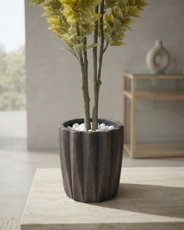 Tall artificial foliage plant in a dark textured decorative planter