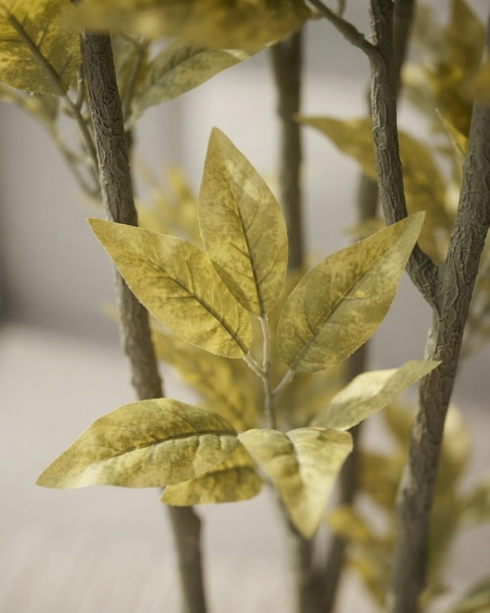 Close-up of artificial yellow-green leaves on tall stems