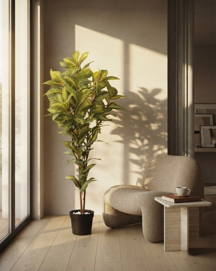 Tall artificial green plant in black decorative pot, full view