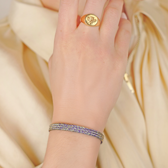 a hand with a gold ring and bracelets