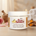 Herby Rose Turmeric face mask jar on a wooden table with roses, turmeric root, and towels for a natural glow.
