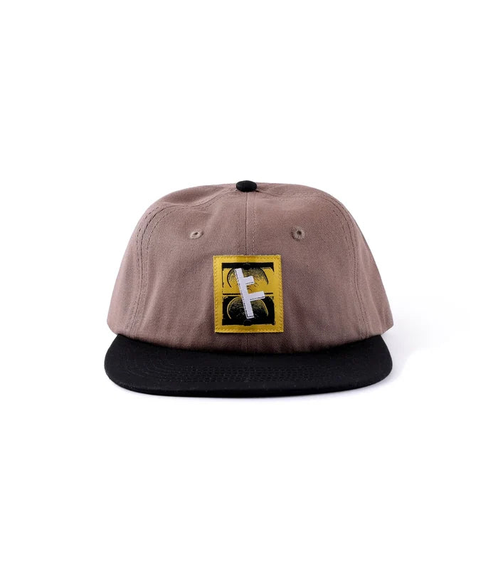 Former Slant F logo detail on brown cap close-up