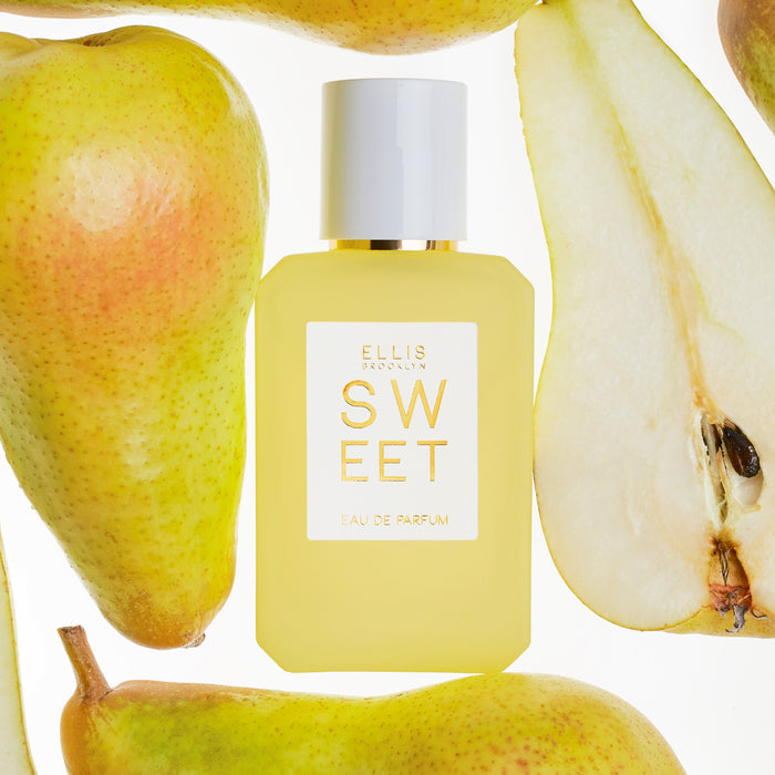 SWEET Eau de Parfum 50ml between pear halves on white background