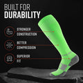Neon green tall compression sock with gray heel and toe, displayed on dark stone surface