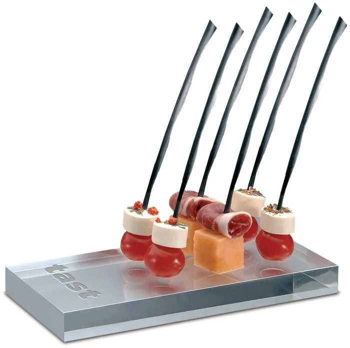 A pack of black plastic skewers, 7 inches long, displayed with food on them on a white background.