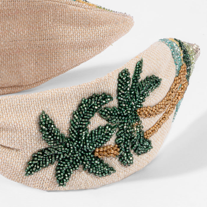 Resort-inspired knotted headband with hand-beaded palm trees and shimmering sequin details on linen