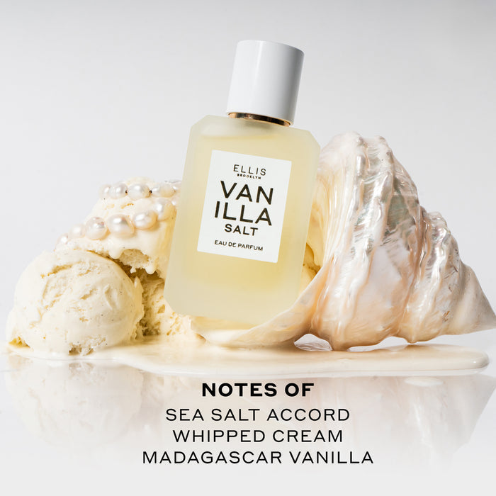Vanilla Salt 50ml Eau De Parfum resting on white shell in melted vanilla ice cream next to scoops of vanilla ice cream and pearls on white background above black text that reads "Notes Of Sea Salt Accord, Whipped Cream, Madagascar Vanilla".
